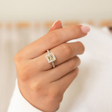 Hand wearing a diamond ring with a blurred background