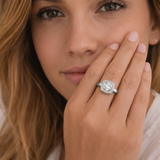 Woman wearing a diamond ring on her finger with a soft focus background