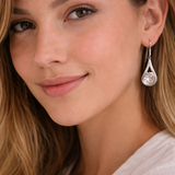 Close-up of a woman wearing a silver teardrop earring.