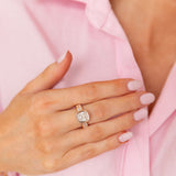 Hand wearing a ring with a pink shirt in the background