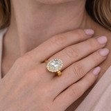 Gold ring with a large diamond on a hand against a soft background